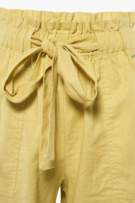 Gele short van MEXX met een strikceintuur en een elastische tailleband, close-up.
