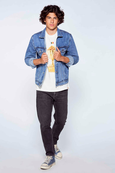 Witte T-shirt met gouden trofeeprint van MORA, gedragen onder een jeansjack, lifestyle shot.