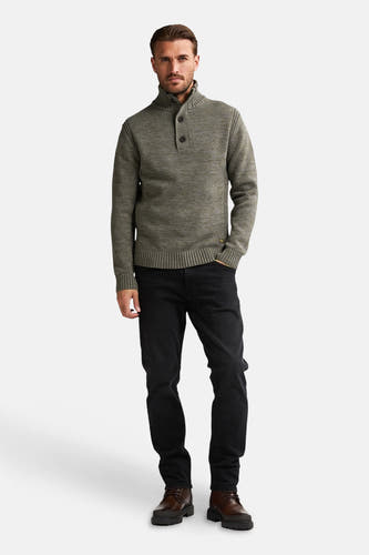 Groene trui met ronde hals van Petrol Industries®, met knoopdetail en zwarte jeans en bruine schoenen.
