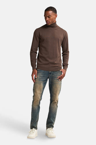 Manteau brun de Petrol Industries® à longues manches, associé à des jeans bleus et des baskets blanches.