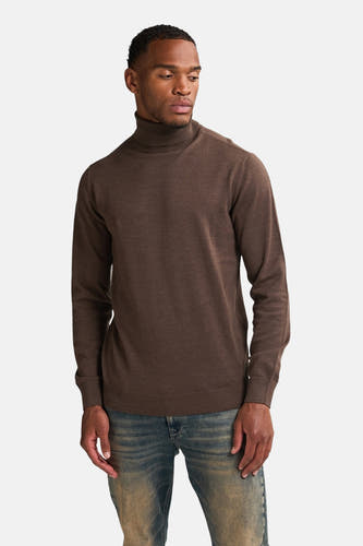 Pull marron avec col montant de Petrol Industries, porté avec des jeans bleus.