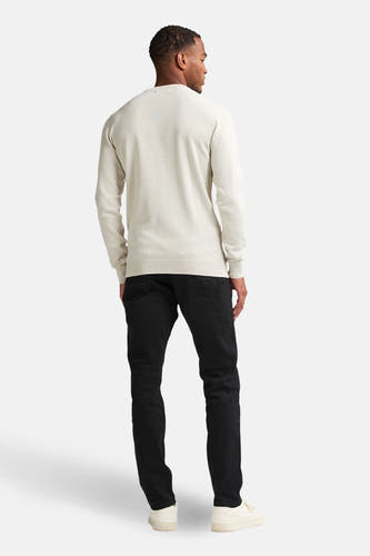 Ecrukleurige trui met ronde hals van Petrol Industries, gezien vanaf de achterkant, met donkere jeans en crèmekleurige schoenen.
