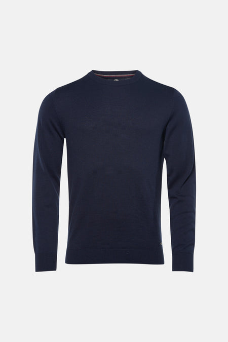 Pull bleu à col rond de Petrol Industries®, porté avec un jean clair et des baskets blanches.