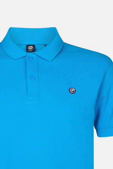 Blauwe polo met korte mouwen van Petrol Industries, met een gebreide kraag en een embleem op de borst.
