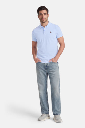 Blauw poloshirt met korte mouwen van Petrol Industries®, gedragen met een jeans en grijze sneakers.
