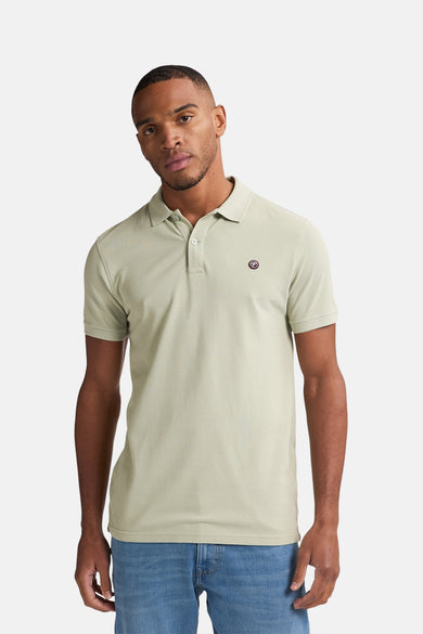 Groene polo met korte mouwen van Petrol Industries®, met logo op de borst, gedragen met een jeans.
