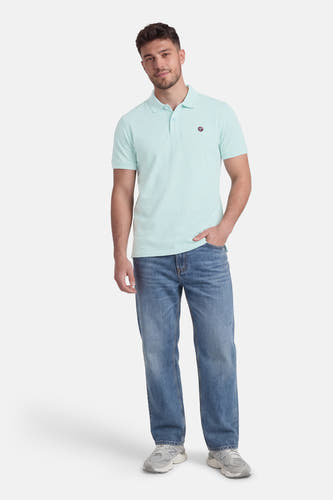 Groene polo met korte mouwen van Petrol Industries®, gedragen met jeans en grijze sneakers.