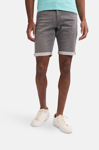 Grijze jeansshort van Petrol Industries®, met opgerolde pijpen en gecombineerd met lichte sneakers.