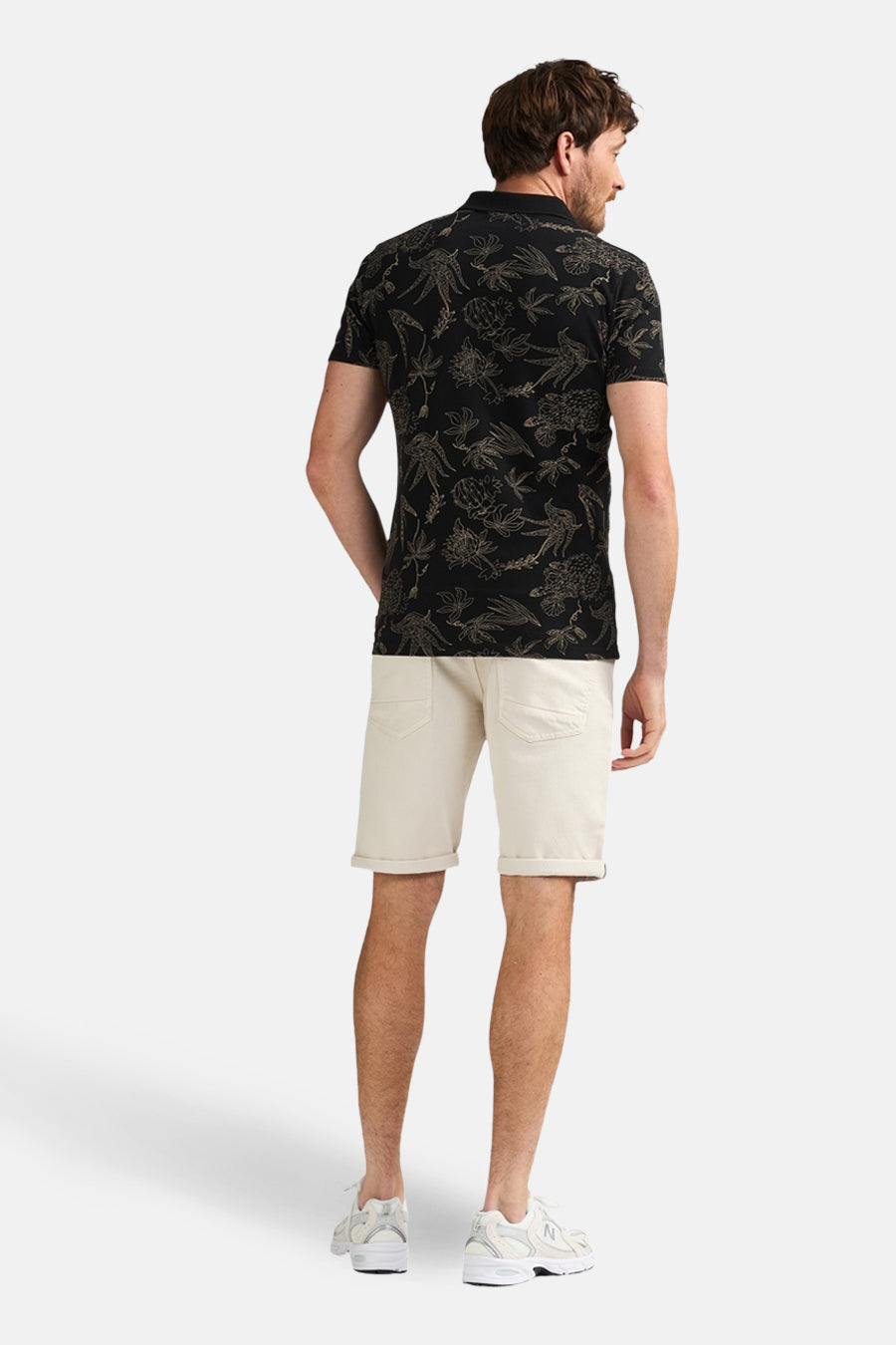 Ecru short van Petrol Industries, met omgeslagen broekspijpen, gecombineerd met een zwart poloshirt met print.