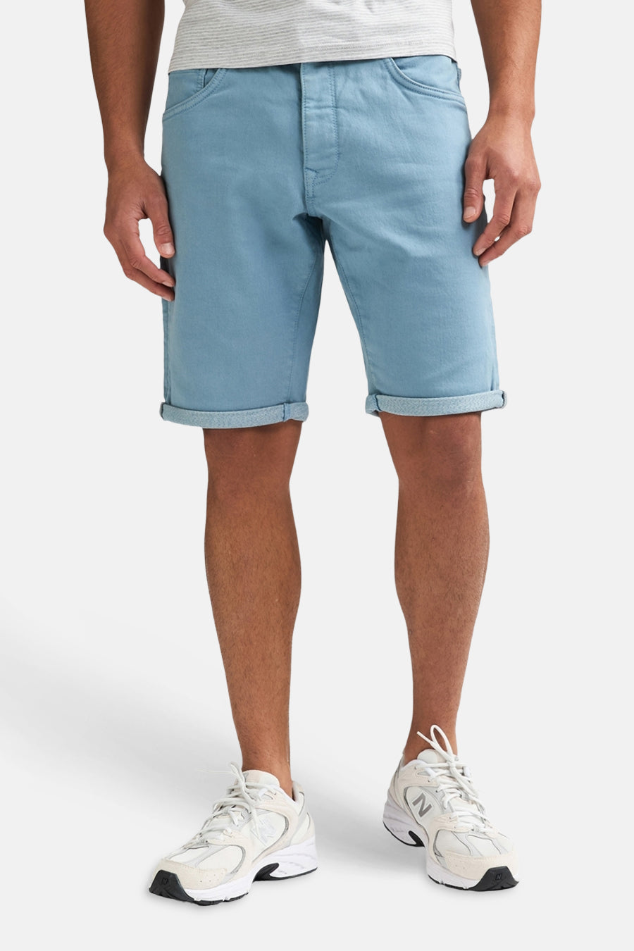 Blauwe short van Petrol Industries® met opgerolde zomen, gedragen door een man met een grijs gestreept T-shirt en witte sneakers.