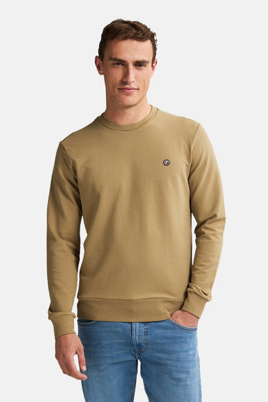 Groene sweater van Petrol Industries® met een klein logo op de borst en lange mouwen, gedragen met jeans.

