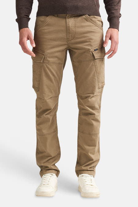 Pantalon cargo Bruine de Petrol Industries® avec grandes poches et genoux renforcés, porté avec un pull foncé et des baskets blanches, vue de face