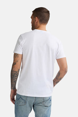 T-shirt blanc à manches courtes de Petrol Industries, avec des tatouages sur le dos et les bras, et un short en jean bleu.