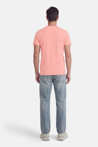 Roze T-shirt met korte mouwen van Petrol Industries, gezien van achteren, met jeans en witte sneakers.