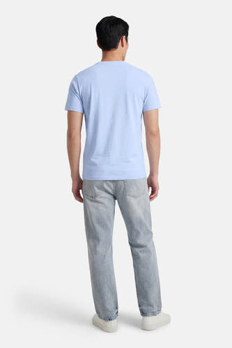 Blauw T-shirt met korte mouwen van Petrol Industries, gezien van achteren, met lichte jeans en witte sneakers.