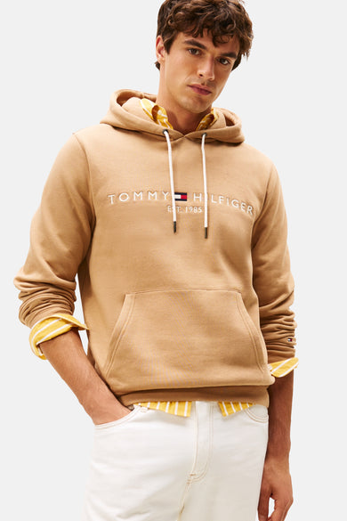 Beige sweater met ronde hals van Tommy Hilfiger, gedragen over een gestreept overhemd en met witte broek.