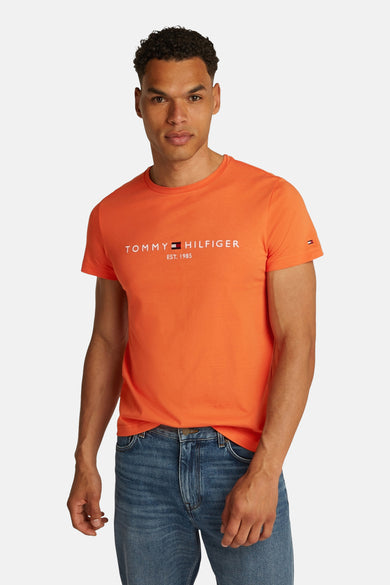 T-shirt à manches courtes orange de TOMMY HILFIGER, avec vue arrière et combiné avec un jean bleu et des baskets beiges.