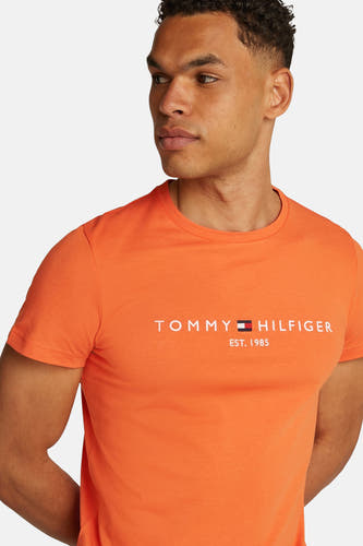 T-shirt à manches courtes orange de Tommy Hilfiger, avec le logo et 'Est. 1985' sur la poitrine.