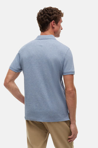 Blauwe polo van TOMMY HILFIGER van melange stof, achteraanzicht op een man met khaki broek.