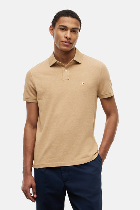 Beige pique polo van TOMMY HILFIGER met korte mouwen, klein borstlogo en donkerblauwe broek.