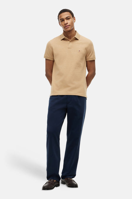 Beige polo van TOMMY HILFIGER met klassieke kraag, korte mouwen en een klein logoborduurwerk op de borst.