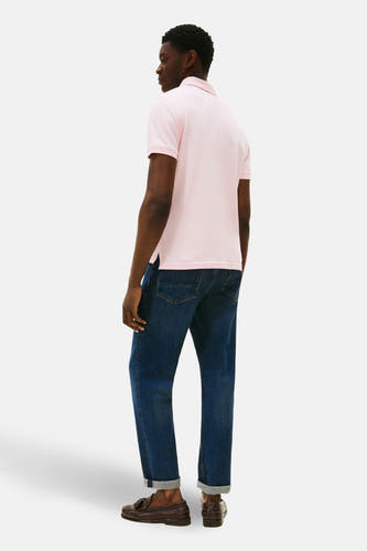 Roze polo met korte mouwen van TOMMY HILFIGER, met een klassieke kraag en gedragen met donkere jeans en bruine loafers.