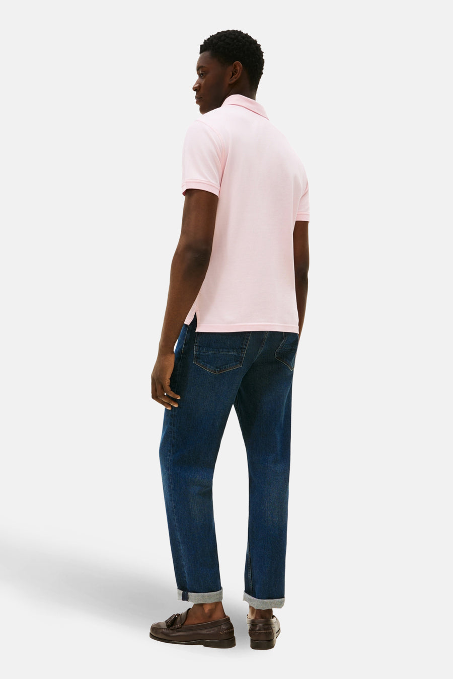 Roze polo met korte mouwen van TOMMY HILFIGER, met een klassieke kraag en gedragen met donkere jeans en bruine loafers.