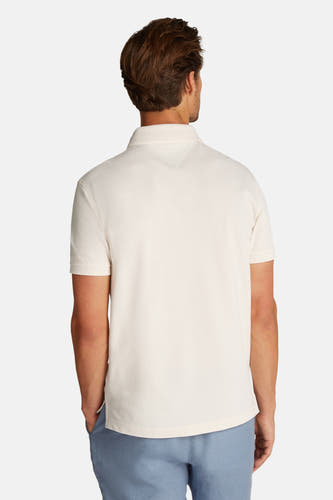 Ecru polo met korte mouwen van TOMMY HILFIGER, achterkant, met lichtblauwe broek.