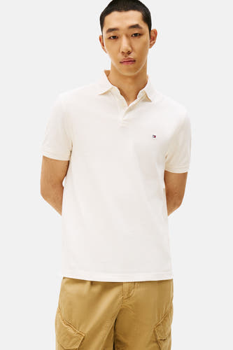 Ecru polo met korte mouwen van Tommy Hilfiger, met geborduurde logo details en gedragen met een kaki cargobroek.