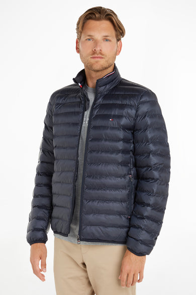 Veste de pluie bleue de TOMMY JEANS, avec des coutures horizontales, sur un modèle portant un t-shirt gris et un pantalon kaki.