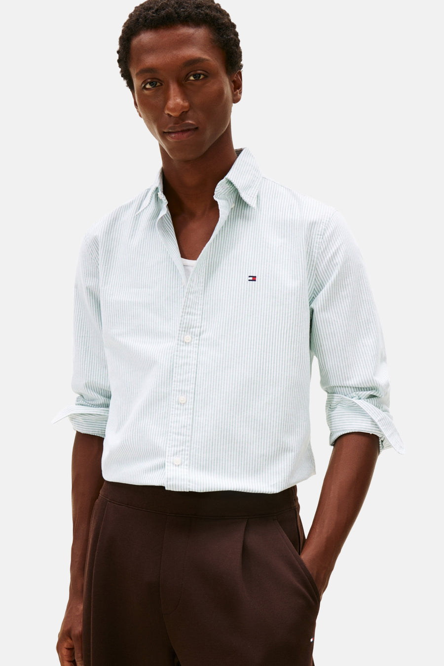 Groen gestreept overhemd met lange mouwen van TOMMY HILFIGER, gedragen met bruine broek met plooien en opgerolde mouwen.
