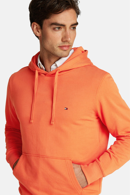 Pull-over orange Tommy Hilfiger avec capuche, avec des cordons et une poche à l'avant.