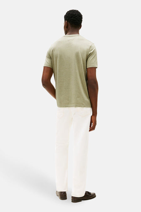 Groen T-shirt met korte mouwen van TOMMY HILFIGER, gezien van achteren, gecombineerd met een witte broek en bruine loafers.

