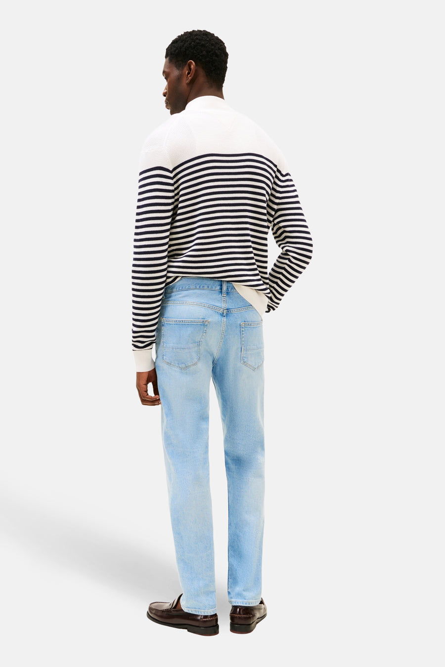 Jean droit en denim bleu clair de TOMMY HILFIGER, avec un dos et des mocassins en cuir marron.