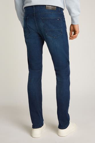Jeans straight van donkerblauw denim van Tommy Hilfiger, achterkant getoond met witte sneakers en lichtblauwe sweater.