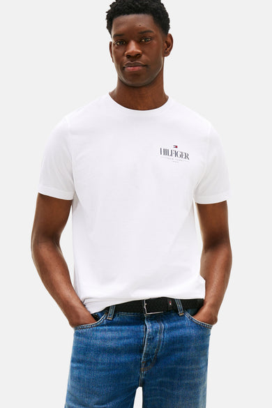 Wit T-shirt met korte mouwen van Tommy Hilfiger, met logo op de borst, gecombineerd met blauwe jeans en zwarte riem.
