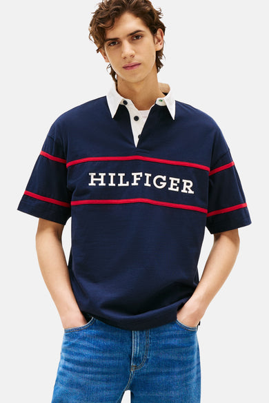 Blauw poloshirt met korte mouwen van Tommy Hilfiger, met witte kraag en rode strepen met merknaam op de borst.