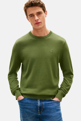 Groene trui met ronde hals van TOMMY HILFIGER, effen textuur, gedragen met een blauwe spijkerbroek.