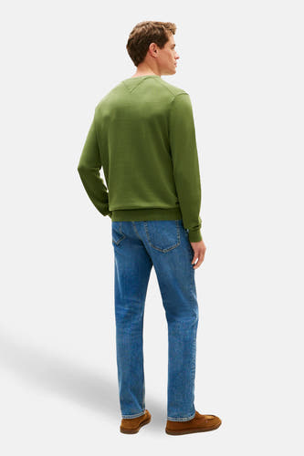 Groene trui met ronde hals van TOMMY HILFIGER, gezien van achteren, met jeans en bruine schoenen.