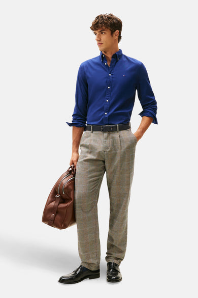 Blauw, lange mouwen overhemd van Tommy Hilfiger, gedragen met een geruite broek en een leren tas.