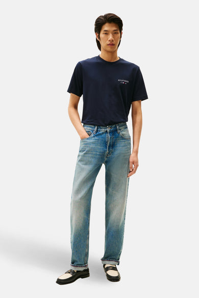 T-shirt bleu à manches courtes de Tommy Hilfiger, porté avec un pantalon de travail et des loafers.