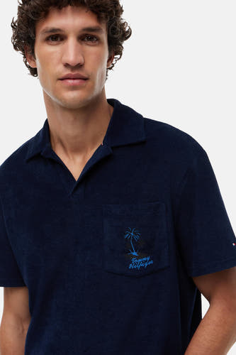 Donkerblauwe badstof polo van Tommy Hilfiger met open kraag en geborduurd palmboomlogo op de borstzak.