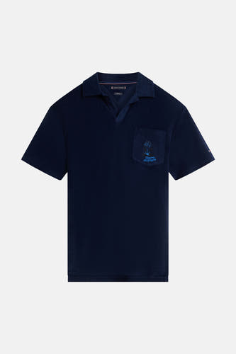 Polo en tissu éponge bleu de TOMMY HILFIGER avec col ouvert et poche poitrine avec palmier brodé et logo de la marque.