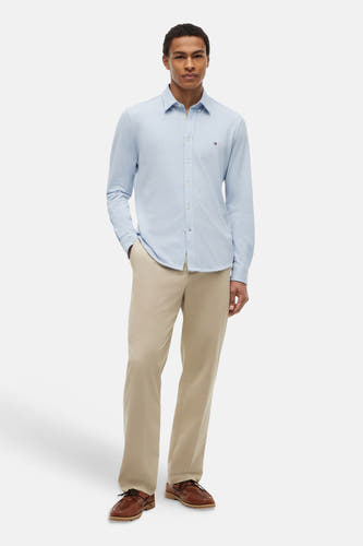 Lichtblauw lange mouwen overhemd van TOMMY HILFIGER, gestreept, met klein logo op borstzak, gedragen met beige broek en bruine schoenen, front view.