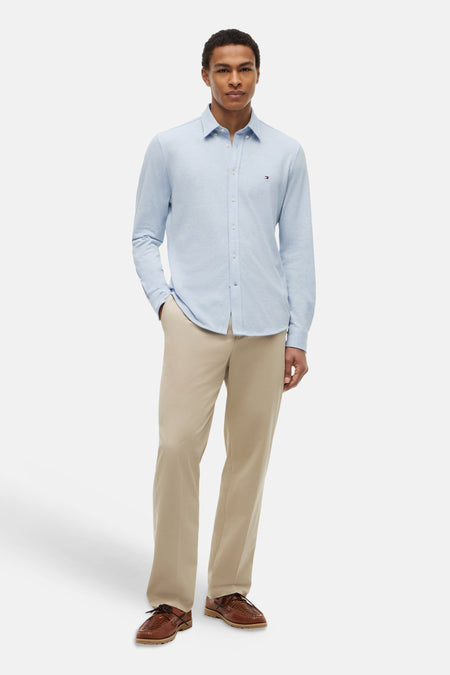 Lichtblauw lange mouwen overhemd van TOMMY HILFIGER, gestreept, met klein logo op borstzak, gedragen met beige broek en bruine schoenen, front view.