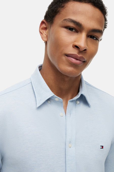 Lichtblauw overhemd van TOMMY HILFIGER, met witte knopen en klein logo op borst, close-up van model