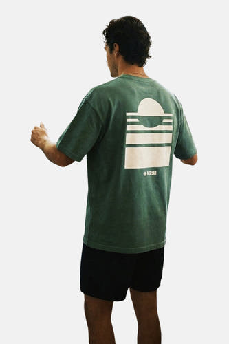 Groen T-shirt met korte mouwen van BASELAB, met witte print op de rug, gedragen met een zwarte korte broek.
