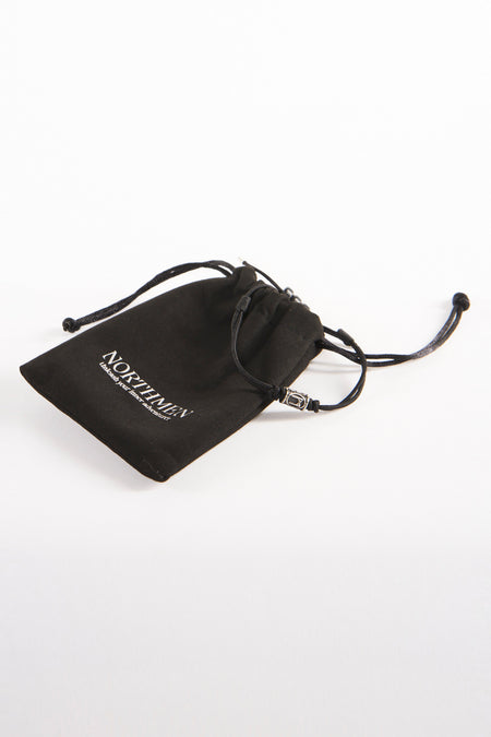 Zwarte armband van NORTHMEN, gepresenteerd in een bijpassend zwart stoffen zakje met trekkoord.

