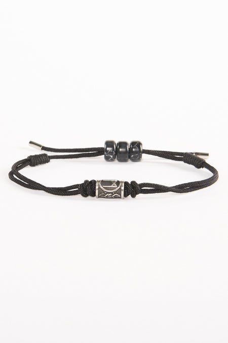 Zwarte armband van NORTHMEN met een zilverkleurige kraal en drie zwarte kralen, op een witte achtergrond.

