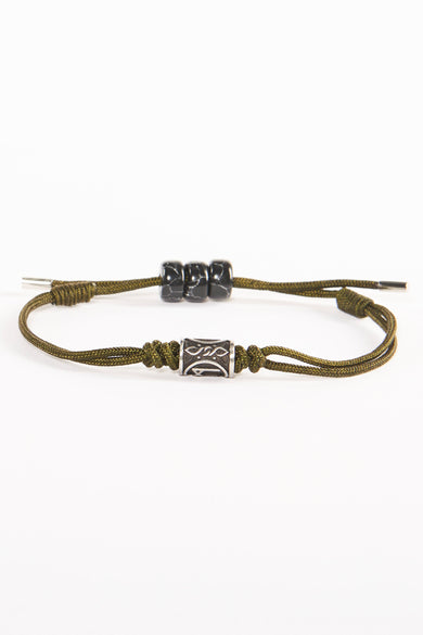 Bracelet brun de NORTHMEN avec des pierres noires et une boucle en argent, forme cylindrique avec des motifs décoratifs.